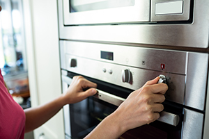 Woman turning on the oven